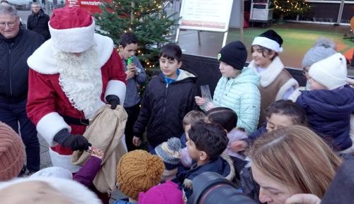 Weihnachtsmarkt Nikolaus verteilt Schokolade an Kinder